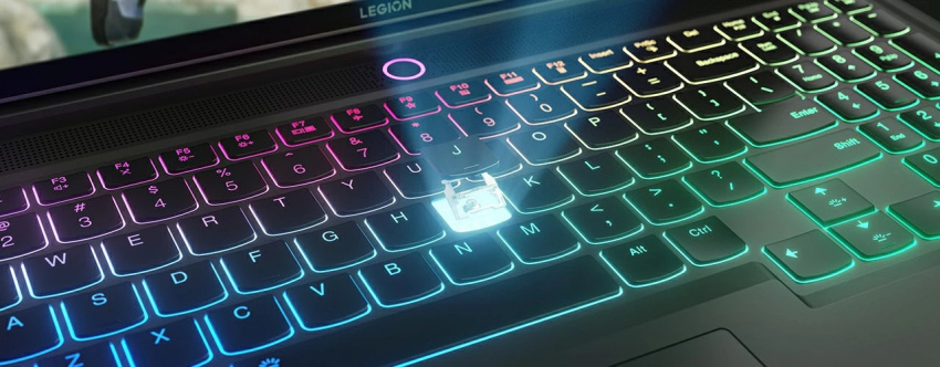 The multicolor illuminated keyboard of the Lenovo Legion Slim 7i Gen 8 (16 Intel), with a breakaway view of the “J” key showing components