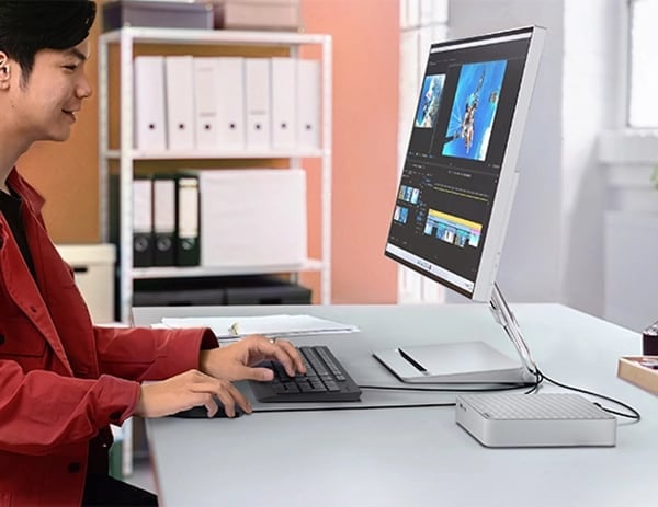 Person working at desk with IdeaCentre Mini Gen 8 connected to keyboard, mouse and display